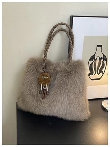 Detailed close-up of plush brown crossbody bag with woven handle and cute bear charm