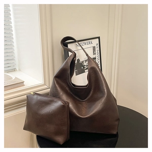 Close-up of a large dark brown faux leather tote bag with a matching small zipper pouch