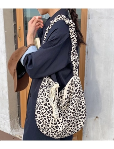 Detail of leopard print canvas crossbody bag with wide strap and pearl charm accessories