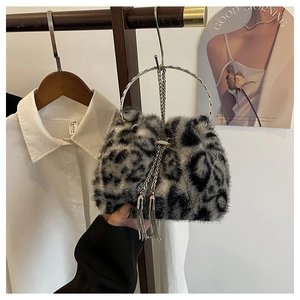 Close-up of leopard print faux fur bucket bag with silver metal handle and fringe tassel
