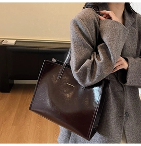 Detail der dunkelrotbraunen Lackleder-Tote Bag mit der Aufschrift FASHION & BAGS