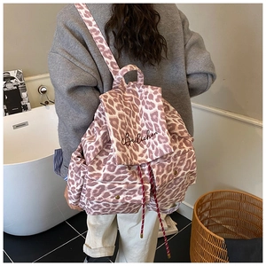 Detail view of pink leopard print canvas backpack with drawstring closure and front pockets