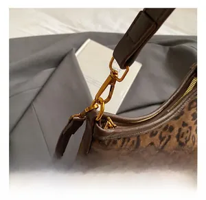 Close-up of leopard print shoulder bag with gold metal hook and zipper details