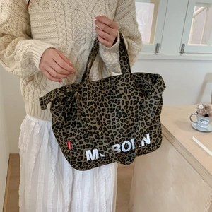 Détail du sac cabas en toile à motif léopard avec texte MOBORN et sangles robustes