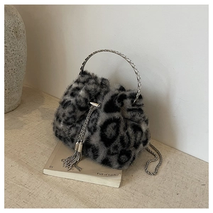 Detail of leopard print faux fur bucket bag with silver metal handle and tassel