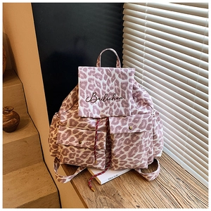 Detail of pink leopard canvas backpack with front flap pockets and embroidered brand logo