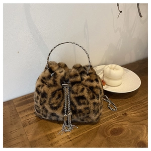Detail of leopard print faux fur bucket bag with silver metal handle and chain tassel