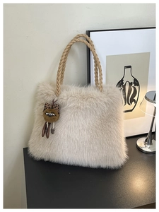 Detailed macro view of soft faux fur tote bag with braided brown handles and leopard charm