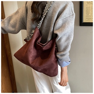 Detail of burgundy frosted leather tote with stylish black and white striped ribbon strap