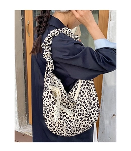 Detail of canvas leopard print bag with ruched strap and lace pearl pendant decoration