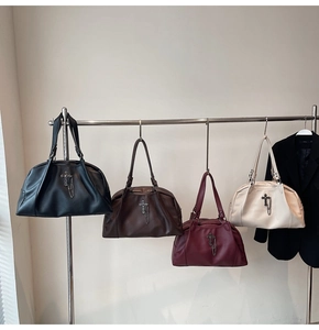 Detailed display of four vintage cross handbags in black, brown, red and white leather