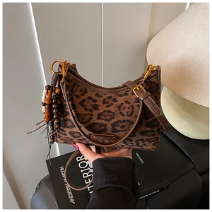 Detail of leopard print shoulder bag with beaded tassel and golden hardware accents