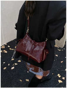 Detail view of burgundy leather hobo bag with side pockets and vintage gold hardware