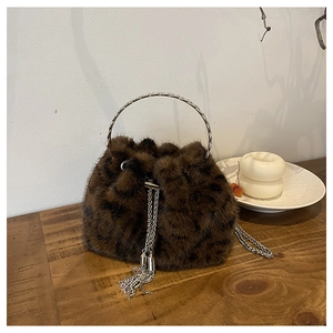Detail of faux fur leopard bucket bag with silver metal ring handle and chain fringe