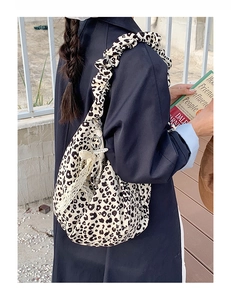 Detail of leopard print tote bag with scrunchie strap and pearl tassel accents