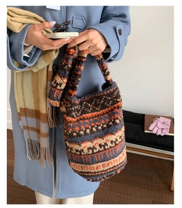 Detail of colorful striped plush tote bag with thick lamb wool texture for winter fashion