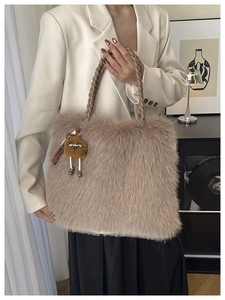 Detail of plush faux fur handbag with woven leather handle and cute monster charm accessory