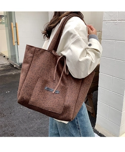 Detailed view of leopard print suede tote bag with front pocket and embossed text label