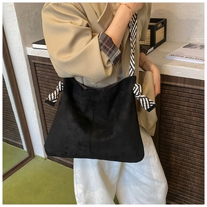 Detail of black matte tote bag with stylish black and white striped woven rope straps
