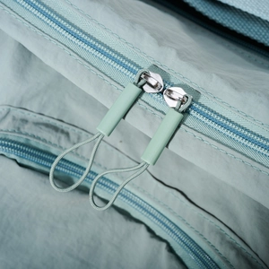 Detailed macro view of the durable double zippers and nylon texture on this tote bag