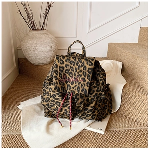 Detail of leopard print canvas backpack with pink embroidery and red drawstring