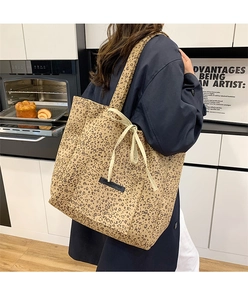 Detail of leopard print suede tote bag with front pocket and decorative drawstring bow