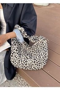 Detail of leopard print canvas tote bag featuring unique ruched handles and spacious design