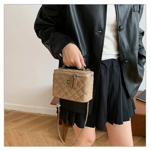Close-up of quilted rhombic pattern shoulder bag with silver chain strap and top handle