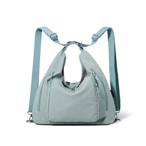 Detailed close-up of light blue waterproof nylon tote with adjustable straps and zipper