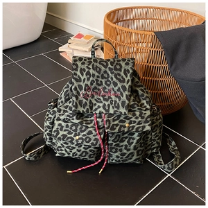 Detail of leopard print canvas backpack with red drawstring and embroidery accents
