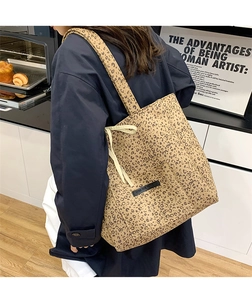 Detail of leopard print suede tote bag featuring black leather label and drawstring
