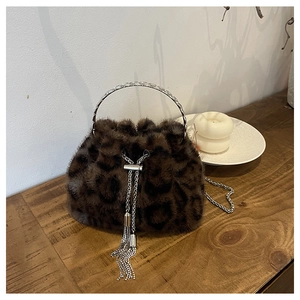 Detailed view of plush leopard print bucket bag with silver metal handle and drawstring
