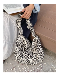 Detail of leopard print tote bag featuring a ruffled cloud strap and silver zipper closure