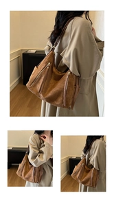 Detailed view of large brown suede tote bag with vintage zippers and long leather tassels