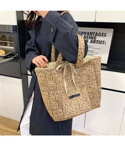 Chic leopard print faux suede tote bag with bow tie closure shown on model in a kitchen