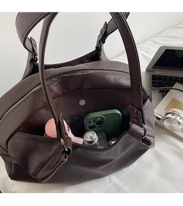 Detail showing the spacious interior and back zipper pocket of this brown leather handbag