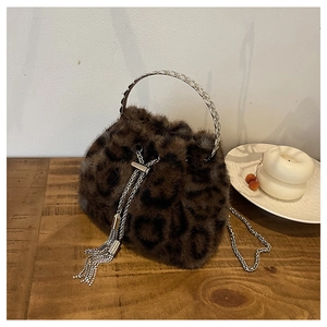 Detail of leopard print faux fur bucket bag with metallic handles and rhinestone tassels