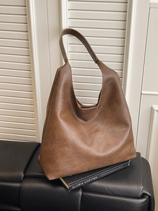 Brown large capacity leather Hobo tote bag with retro pleated texture on dark leather bench
