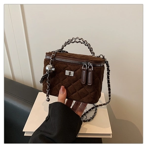 Detailed view of dark brown quilted suede mini box bag with silver chain strap and lock