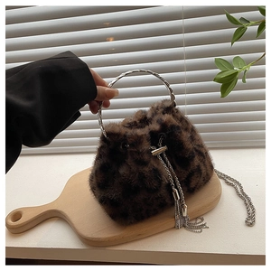Detail of leopard print faux fur bucket bag with silver ring handle and chain tassel