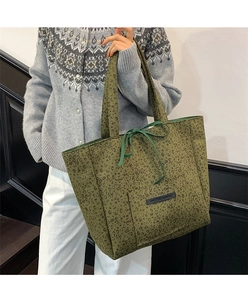 Close-up of leopard print suede tote bag with decorative bow and leather brand label