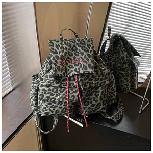 Detailed close-up of leopard print canvas backpack with red embroidery and drawstring