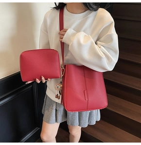 Détail du sac seau rouge à texture litchi avec pochette assortie et breloque hibou