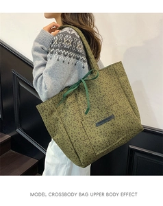 Army green leopard print suede tote bag with bow detail shown on a model's shoulder