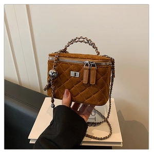 Close-up of brown quilted vanity case with silver chain strap and metal lock detail
