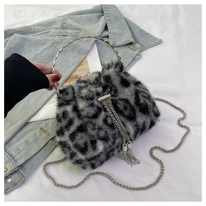 Macro detail of faux fur leopard bucket bag with silver metal handle and chain tassel