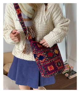 Detail of bohemian knit tote bag with ethnic patterns and thick soft texture on model