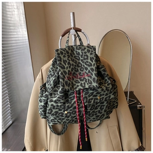 Detailed embroidery logo and red drawstring on a green leopard print canvas backpack