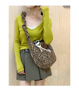 Detailed view of leopard print tote bag featuring ruffled strap and lace pearl pendant