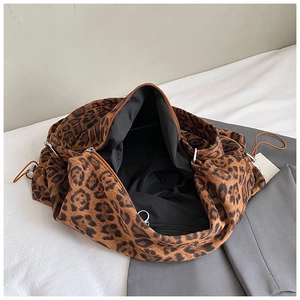 Detail view of large leopard print canvas tote with silver zipper and drawstring hardware